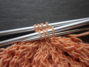 Insert tapestry needle right to left through all stitches on nearer knitting needle