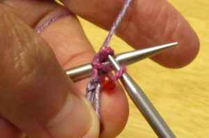 complete the p2tog stitch, taking care that the bead does not come through the new stitch