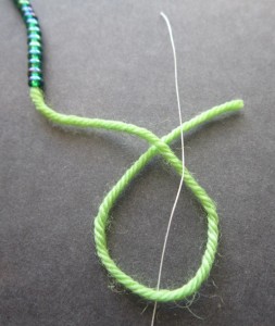 Pull thread up through loop and over the tail